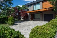 this house features a large driveway and stone path leading to the front door of the house