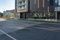 a large building is next to an open street with a car driving down the middle