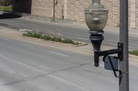 an empty street with a light pole and some traffic signs on it's side