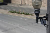 an empty street with a light pole and some traffic signs on it's side