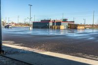 a view down an empty parking lot in the daytime, with only one person walking outside