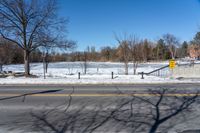 there is snow and a small park on the side of a road by it's side