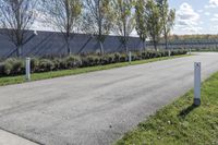 a large parking lot with lots of trees around it and a sidewalk in front of the building