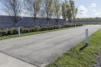 a large parking lot with lots of trees around it and a sidewalk in front of the building