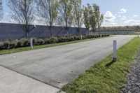 a large parking lot with lots of trees around it and a sidewalk in front of the building