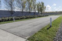 a large parking lot with lots of trees around it and a sidewalk in front of the building