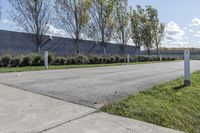 a large parking lot with lots of trees around it and a sidewalk in front of the building