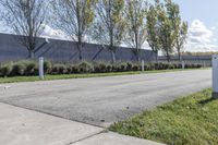 a large parking lot with lots of trees around it and a sidewalk in front of the building