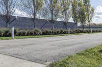 a large parking lot with lots of trees around it and a sidewalk in front of the building