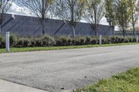 a large parking lot with lots of trees around it and a sidewalk in front of the building