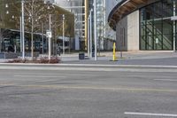 yellow fire hydrant in the middle of a city road surrounded by tall buildings with windows