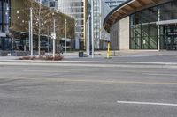 yellow fire hydrant in the middle of a city road surrounded by tall buildings with windows