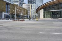 yellow fire hydrant in the middle of a city road surrounded by tall buildings with windows