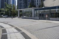 a person sitting at the bench in front of a mall that is empty of people