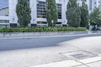 a car driving down an empty street lined with tall buildings and trees in the background