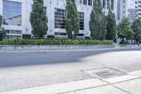 a car driving down an empty street lined with tall buildings and trees in the background