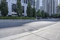 a car driving down an empty street lined with tall buildings and trees in the background