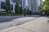 a car driving down an empty street lined with tall buildings and trees in the background