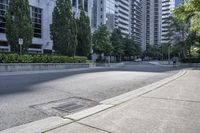 a car driving down an empty street lined with tall buildings and trees in the background