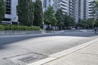 a car driving down an empty street lined with tall buildings and trees in the background