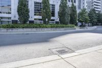 a car driving down an empty street lined with tall buildings and trees in the background