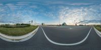 a view from a fish eye lens of a road and a building in the distance