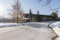 an old, wooden building sits in the background as a snow covered street is covered with snow