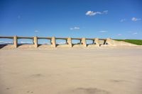 an empty concrete slab, with several pillars and arches, with blue skies and white clouds