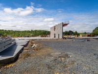 the view of a concrete structure from ground level with trees in background and construction supplies