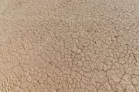 closeup view of cracks in a dry field with no vegetation around it, from below