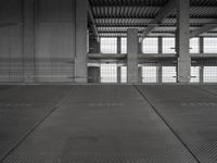 a black and white photo of a building with the door open on a street area