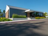 a building that has the front doors open and trees on the sidewalk near by it