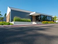 a building that has the front doors open and trees on the sidewalk near by it