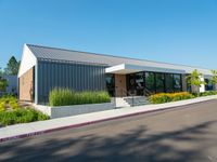 a building that has the front doors open and trees on the sidewalk near by it