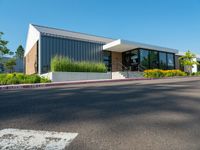 a building that has the front doors open and trees on the sidewalk near by it