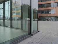 a glass door at an office building is open to let people in, and it's also showing
