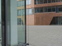a glass door at an office building is open to let people in, and it's also showing