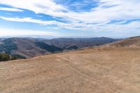 an open mountain with dirt roads leading into the mountains and a wide view of the landscape