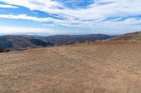 an open mountain with dirt roads leading into the mountains and a wide view of the landscape