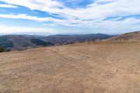 an open mountain with dirt roads leading into the mountains and a wide view of the landscape