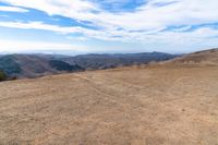 an open mountain with dirt roads leading into the mountains and a wide view of the landscape