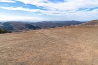 an open mountain with dirt roads leading into the mountains and a wide view of the landscape