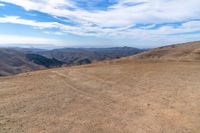 an open mountain with dirt roads leading into the mountains and a wide view of the landscape