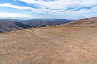 an open mountain with dirt roads leading into the mountains and a wide view of the landscape