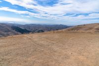 an open mountain with dirt roads leading into the mountains and a wide view of the landscape