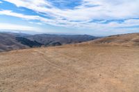 an open mountain with dirt roads leading into the mountains and a wide view of the landscape