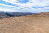 an open mountain with dirt roads leading into the mountains and a wide view of the landscape