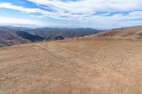 an open mountain with dirt roads leading into the mountains and a wide view of the landscape