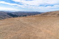 an open mountain with dirt roads leading into the mountains and a wide view of the landscape