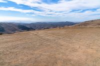 an open mountain with dirt roads leading into the mountains and a wide view of the landscape